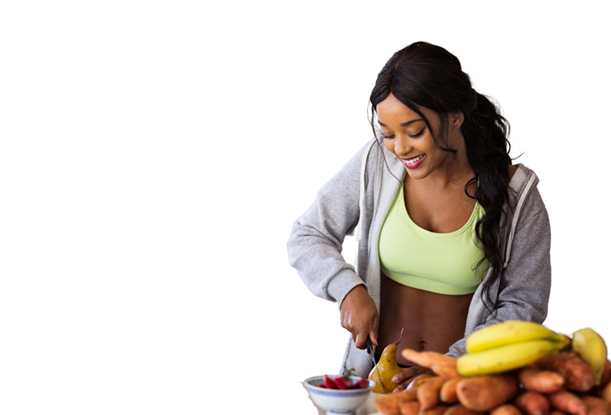 A woman preparing food with various fruits and vegetables on a table.