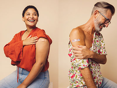 The image shows three individuals with tattoos on their arms, each displaying a different tattoo design, standing side by side against a light-colored background, with one person smiling at the camera.